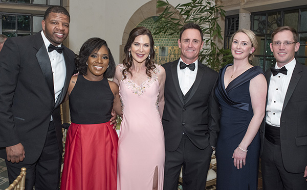 Three couples, one African American and two white, smile at the camera