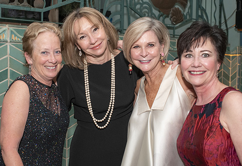 Four women smile at the camera