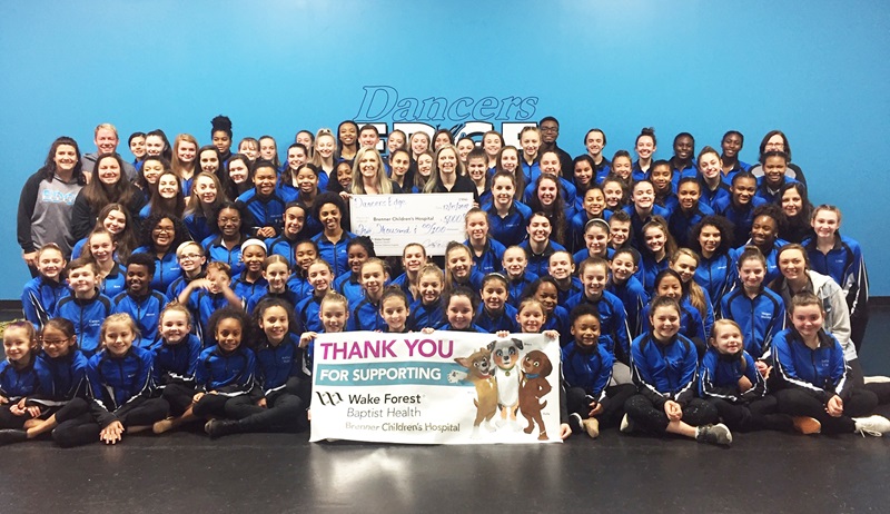 Dancers from Dancers Edge present check to Brenner Children's Hospital