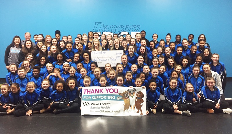 Dancers from Dancers Edge present check to Brenner Children's Hospital