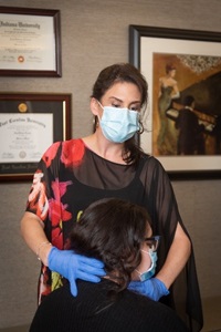 Dr. Morris with patient, checking her throat. 