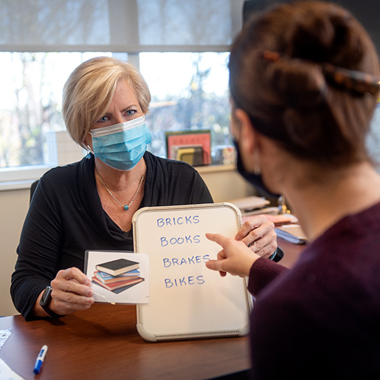 Provider working with patient on speech therapy.