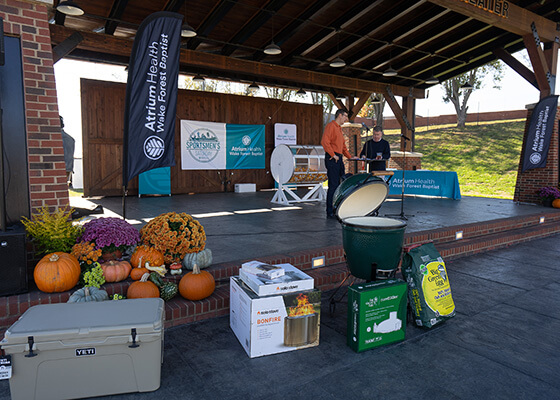 A stage with various auction prizes and sponsor information on it.