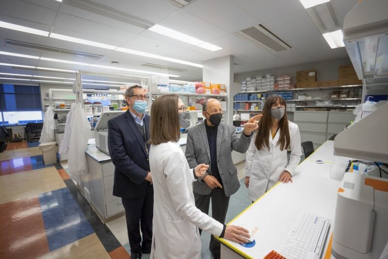 Donor with group of researchers seeing what his donation is accomplishing