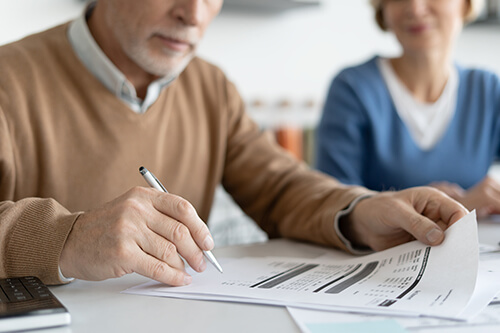 A man and women sitting at a table and filling out paperwork.