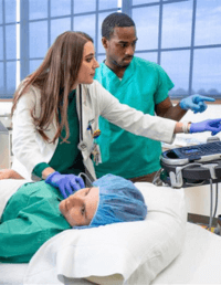 A man and a woman in medical scrubs looking at some documents.