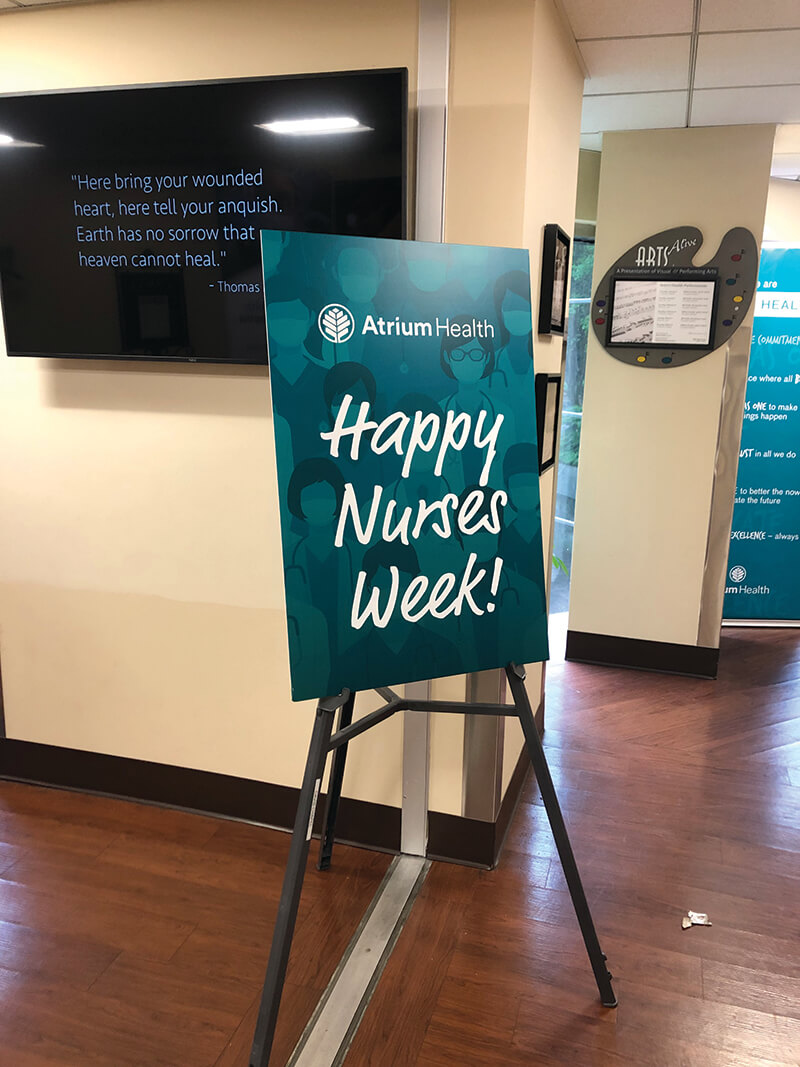A blue sign that reads Happy Nurses Week.