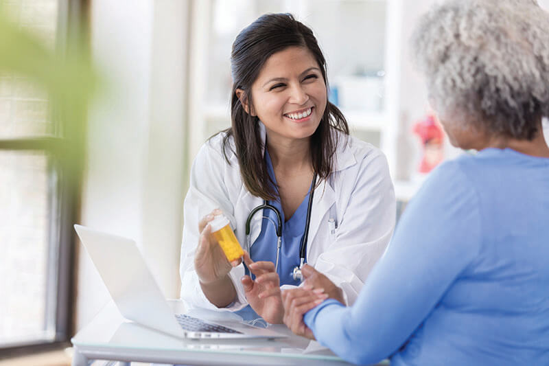 A medical professional going over medication with an older lady.