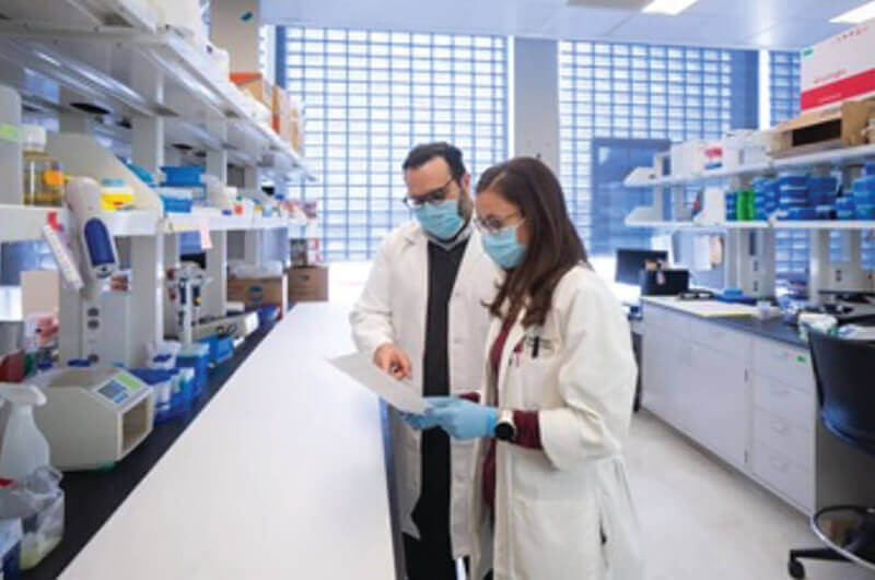 Two medical professionals in a medical setting looking at a paper.