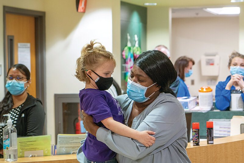 A young girl being held by an older woman.