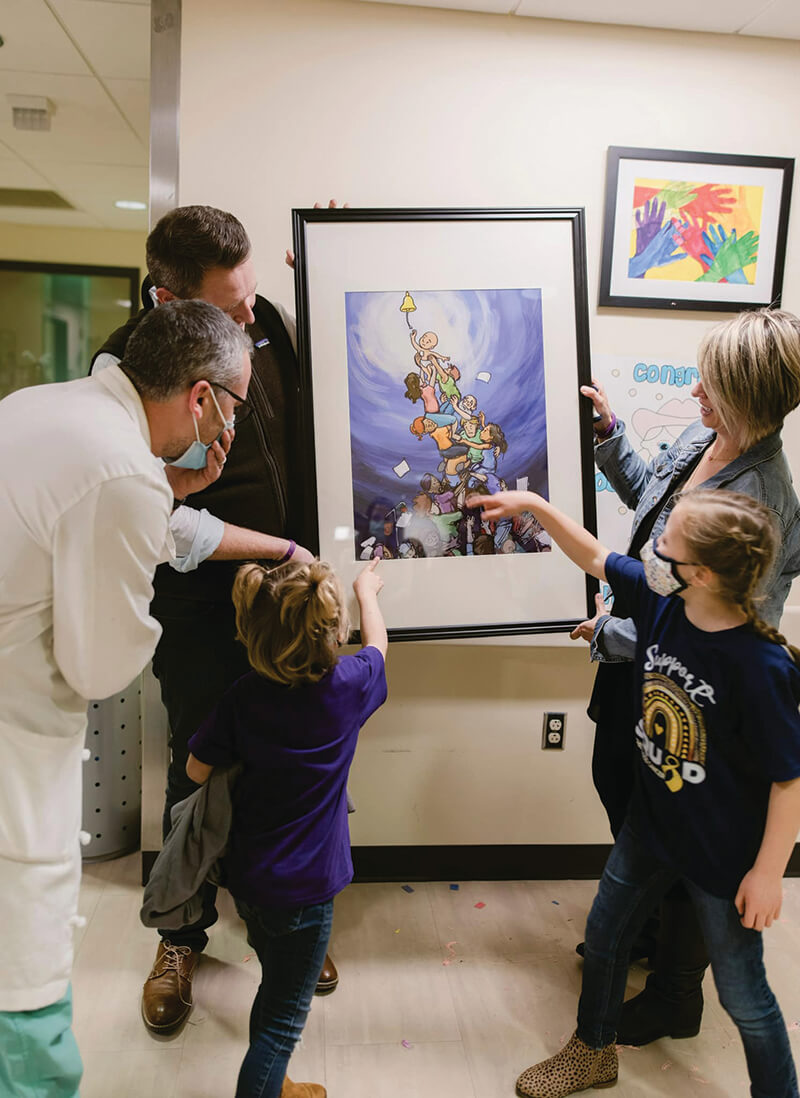 A group of men, women and children looking at a drawing.