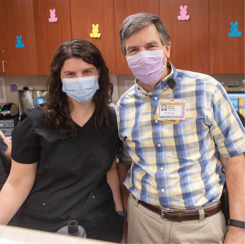 A man and woman standing side-by-side looking at the camera.