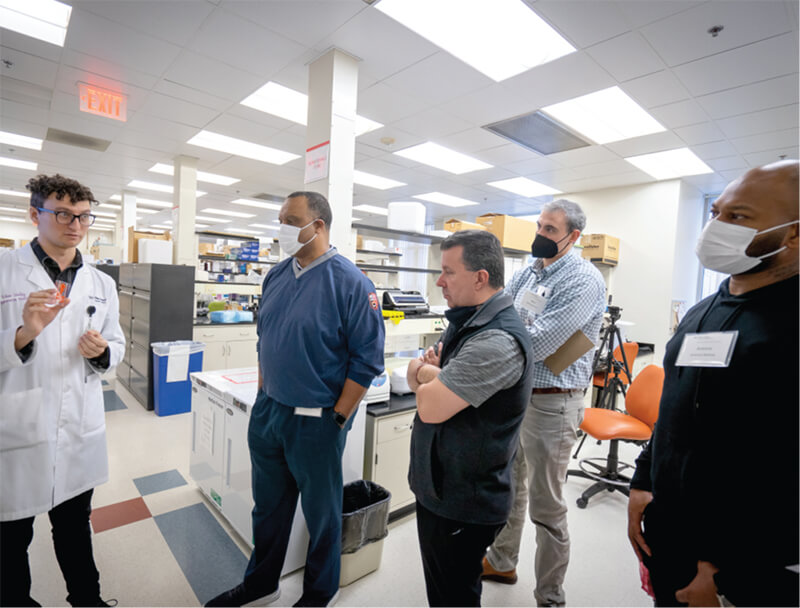 A man in a lab coat giving a group tour.