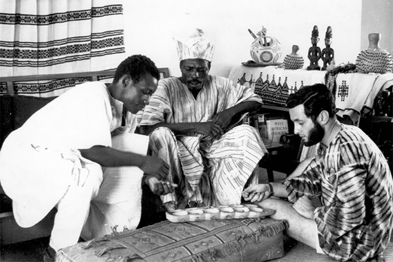 A black and white photo of a group of people sitting around a table.