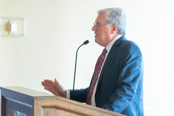 Dr. Koman speaking at podium during an event