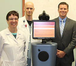 (left to right) Dawn Becker, Stroke Program Coordinator; Dr. Daniel Minior, Emergency Dept. Medical Director and Corey Showers pose with the Telestroke robot. Photo courtesy of Lenoir Memorial Hospital.