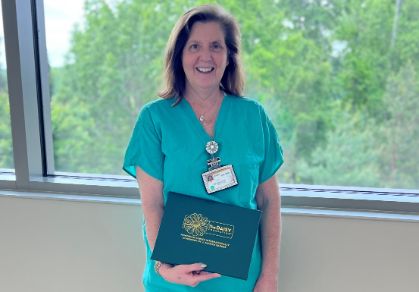 Angie holding Daisy award.