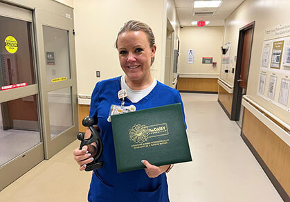 Molly Daniels holding the DAISY Award she won.