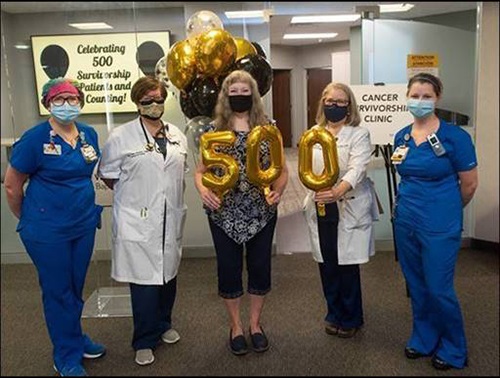 Cathy Way (center) celebrates being the 500th patient at the Cancer Survivorship Clinic with her treatment team.