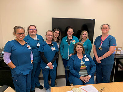 A group of doctors from the Davie Medical Center wearing blue scrubs and name badges.