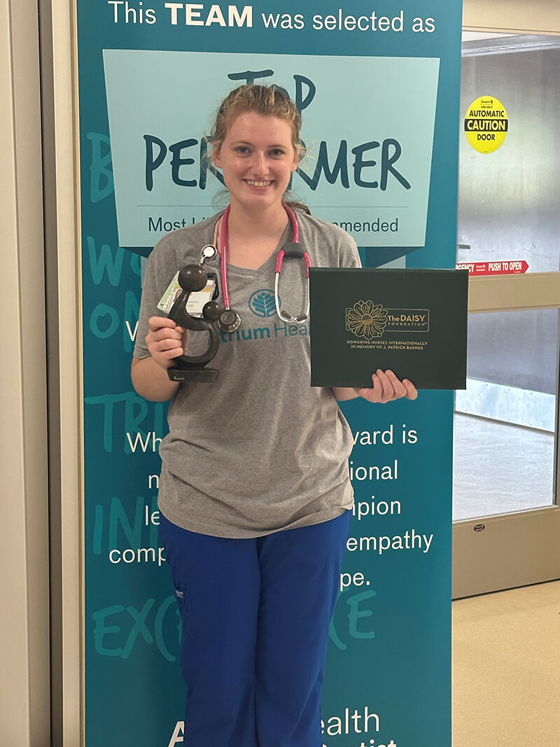 A person holding an award smiling at the camera.