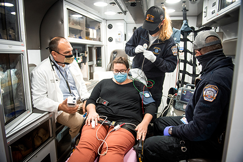 Dr. Jason Stopyra (clockwise from left) demonstrates using an iSTAT device with paramedics Callie Katers and Bubba Killgo, with Wake Forest Baptist employee Rebecca Overman standing in as a patient.