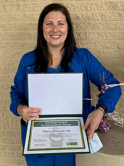 Tiffany Shumate, RN with the DAISY Award in hand.