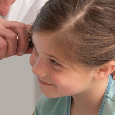 A young child gets examined by a medical provider.