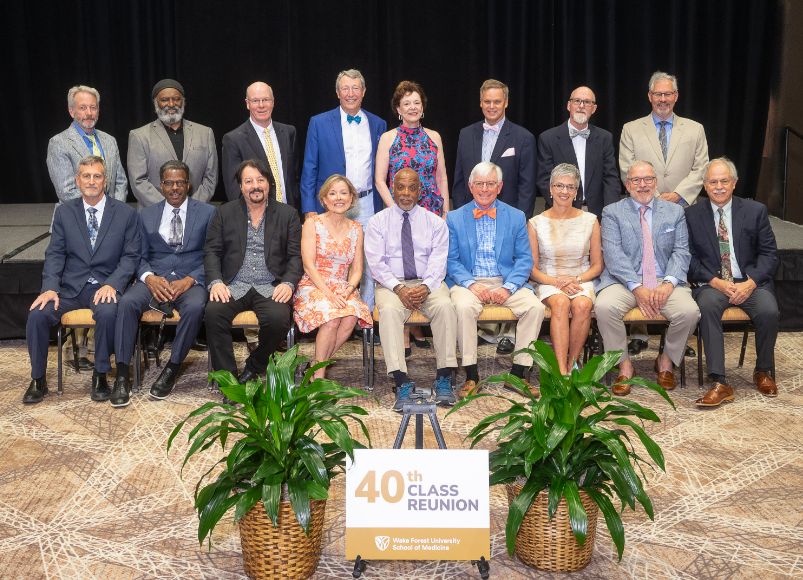Smiling men and women standing and sitting in a 40th reunion photo at Alumni Weekend 2023 at Wake Forest University School of Medicine.