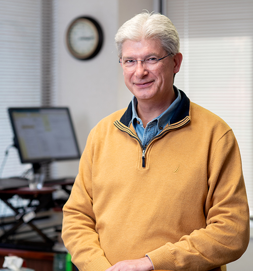 Bryan Hatcher, LCSW and president of CareNet, stands in his office and smiles