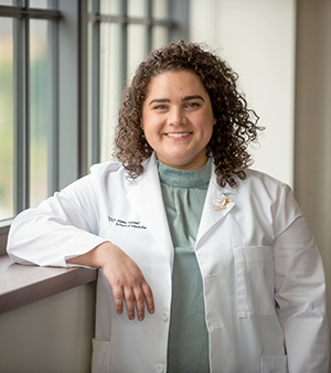 Abby Peoples, MD Class of 2022, smiles as she leans against a windowsill