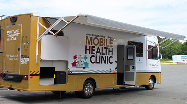 The Wake Forest Baptist Health Mobile Clinic, a converted RV, sits in a parking lot set up for the public to see