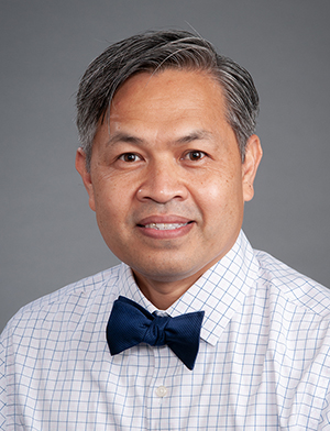 Head shot of Filipino man with gray hair, wearing button-down shirt and bow tie
