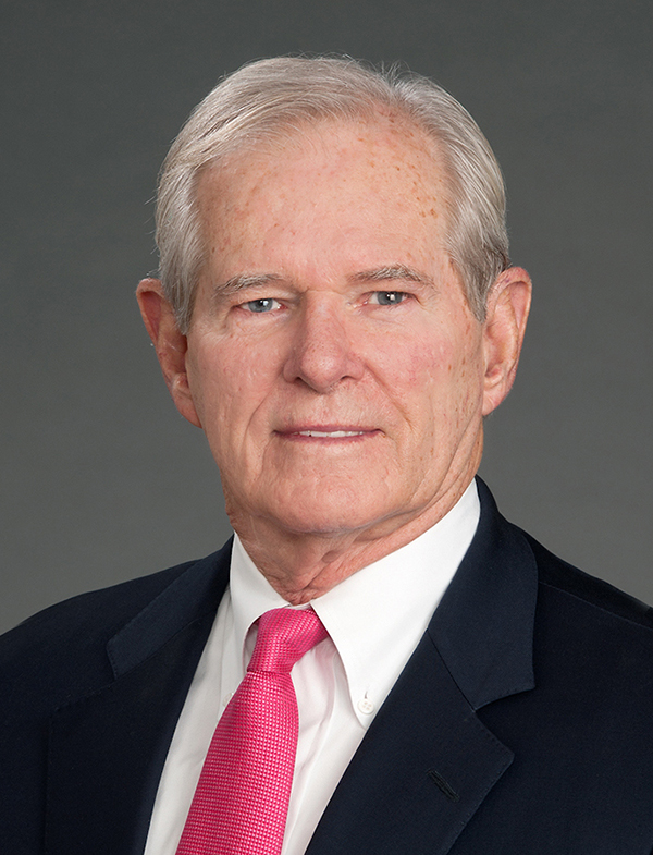 Head shot of older Caucasian man wearing a white shirt, coral tie and dark jacket