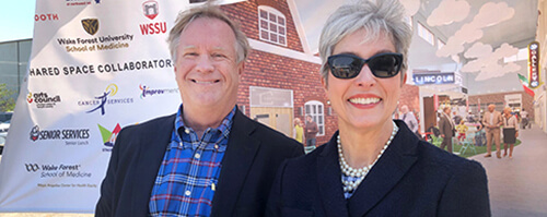 An older man and woman smiling at the camera.