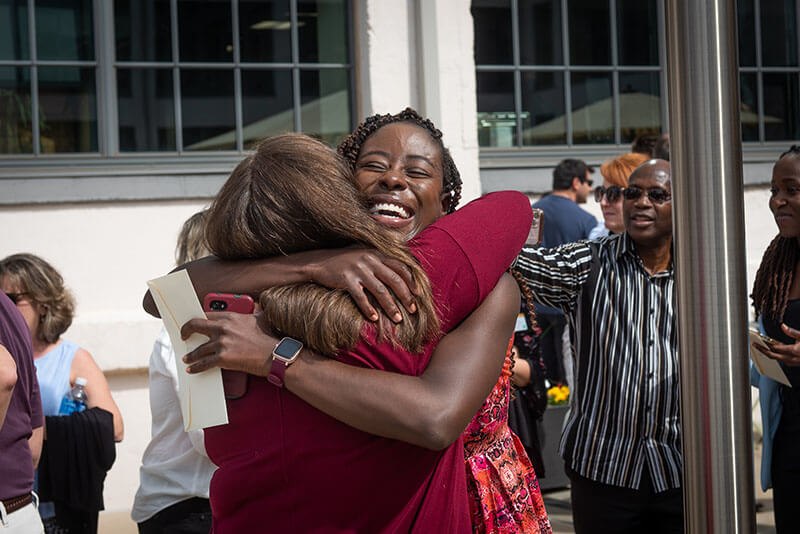 Two women smiling and embracing in a hug.