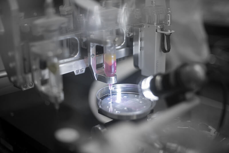 A close-up photo of a laser and petri dish.