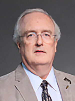 A man wearing a tan suit and looking at the camera.