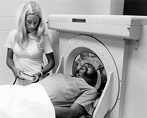 A nurse standing next to a patient in an MRI machine.