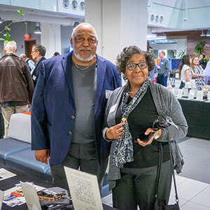 A couple standing side-by-side looking at the camera.