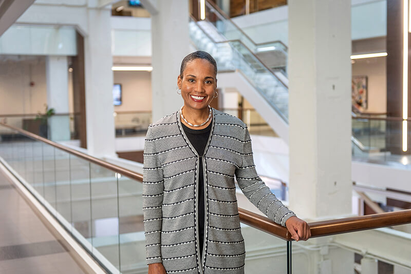 A woman standing on a stairway smiling at the camera.