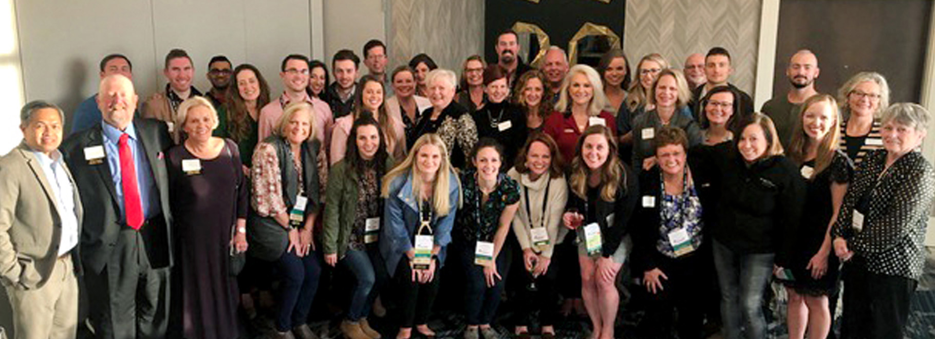 Large group of people stand together and pose for a group photo