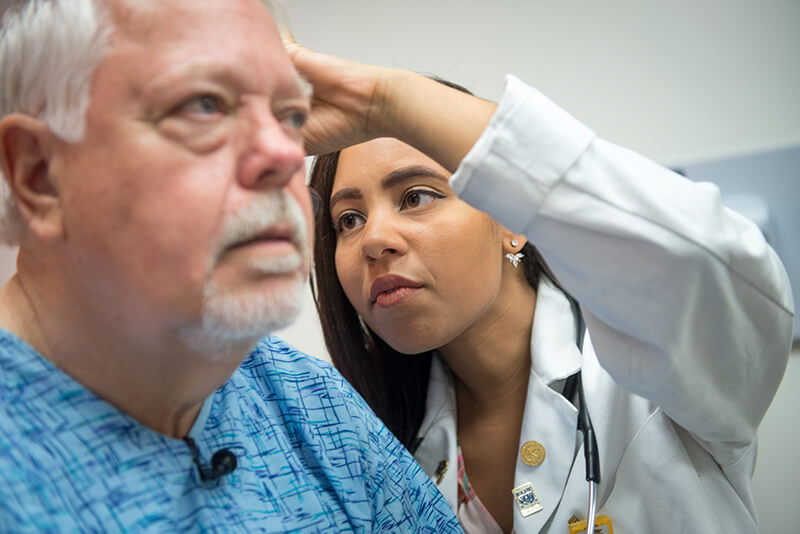 A medical professional working with an older patient.