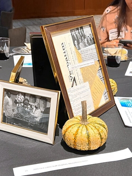Decorations on a table that include a small pumpkin and photos.