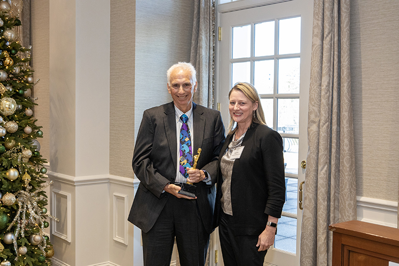 Two people standing side by side and smiling at the camera.