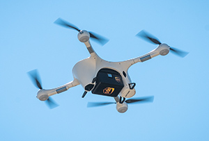 Quadcopter drone with UPS logo against a blue sky