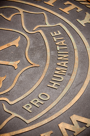 Close-up of a bronze seal with the words 'Pro Humanitate'