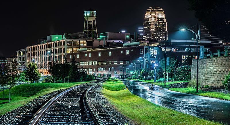 Nighttime view of city skyline lit in shades of blue and green