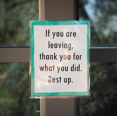 Paper sign on pole reading, 'If you are leaving, thank you for what you did. Rest up.'