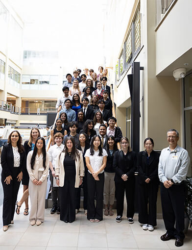 A large group of men and women standing together on a staircase.